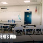 Bright empty classroom featuring desks, a whiteboard, and an American flag. Ideal learning environment.